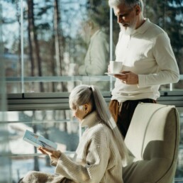 Situations billede af en ældre mand og kvinde som læser et magasin i hjemmet.