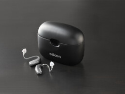 Oticon More miniRite høreapparater ved siden af charger 1.0