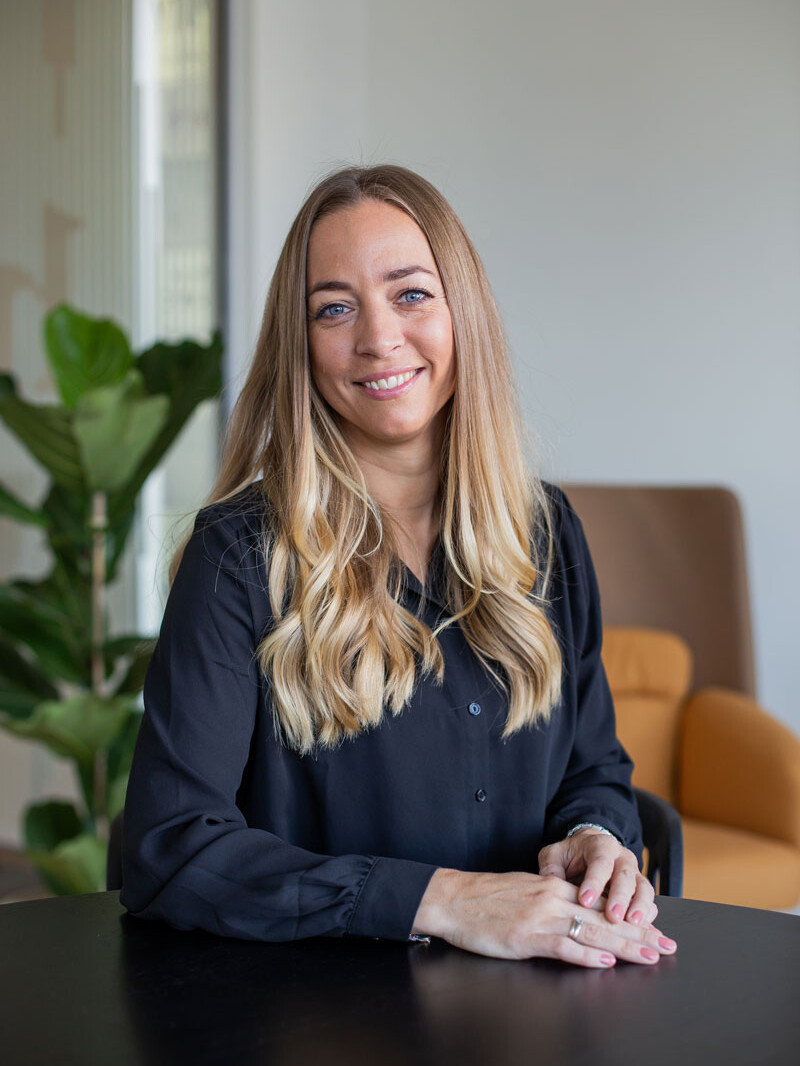 Bettina fra Hørbart sidder ved bord og smiler.