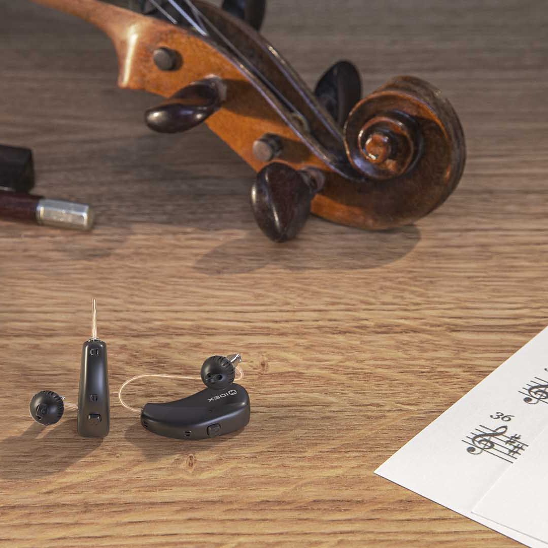 Billede af Widex Moment høreapparater og violin.