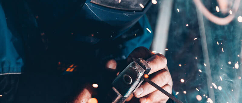 Billede af en svejser med h&oslash;rev&aelig;rn til virksomheder.