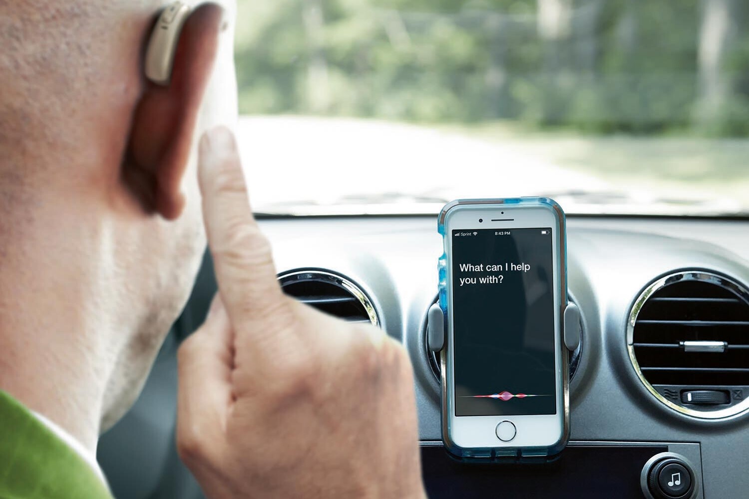 Mand med bluetooth høreapparater og smartphone i bil